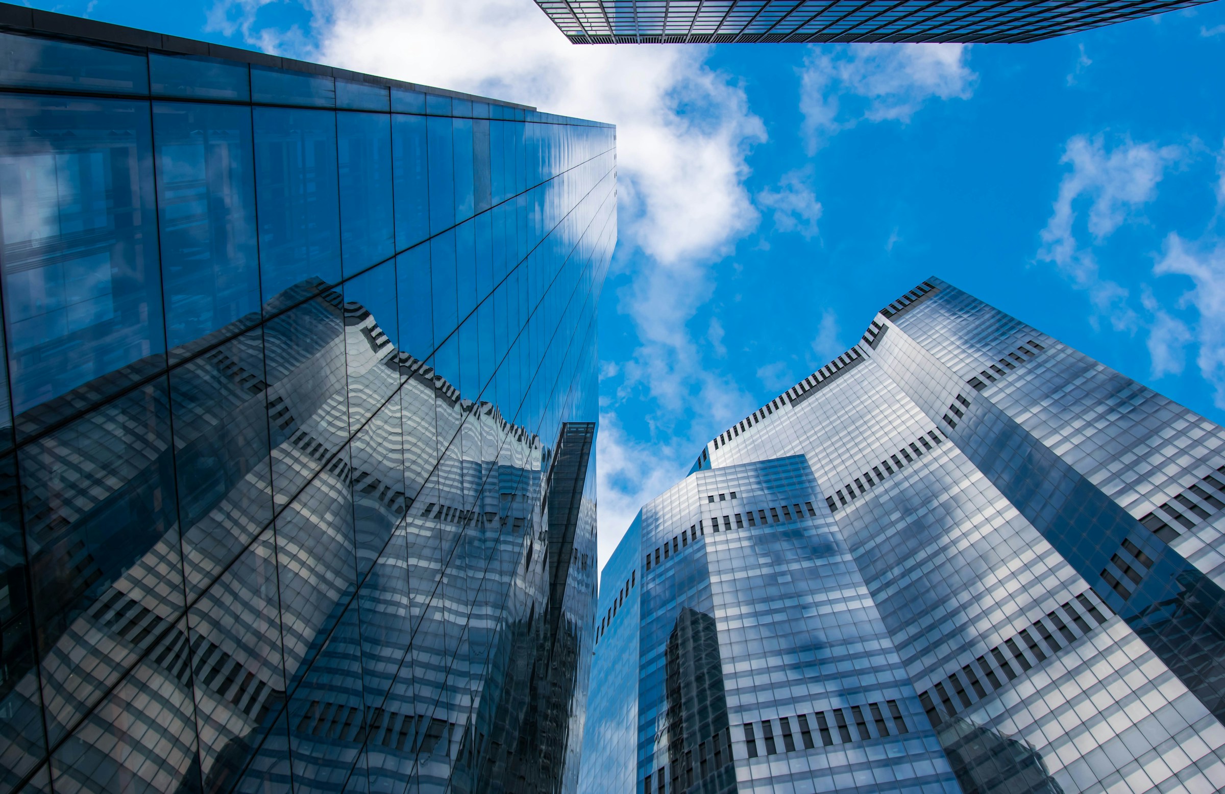looking up in the sky at the outside of multiple tall buildings